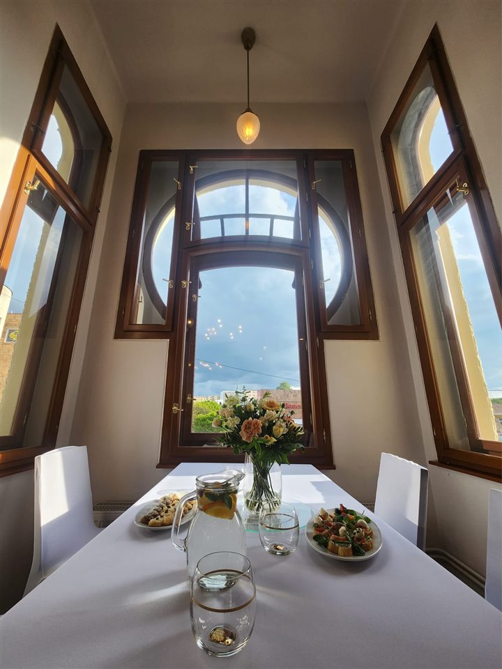 Art deco okno nad slavnostně prostřeným stolem